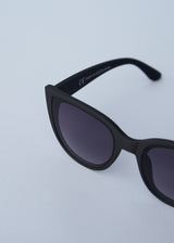 A pair of oversized cat eye sunglasses with black frames and blue lenses
