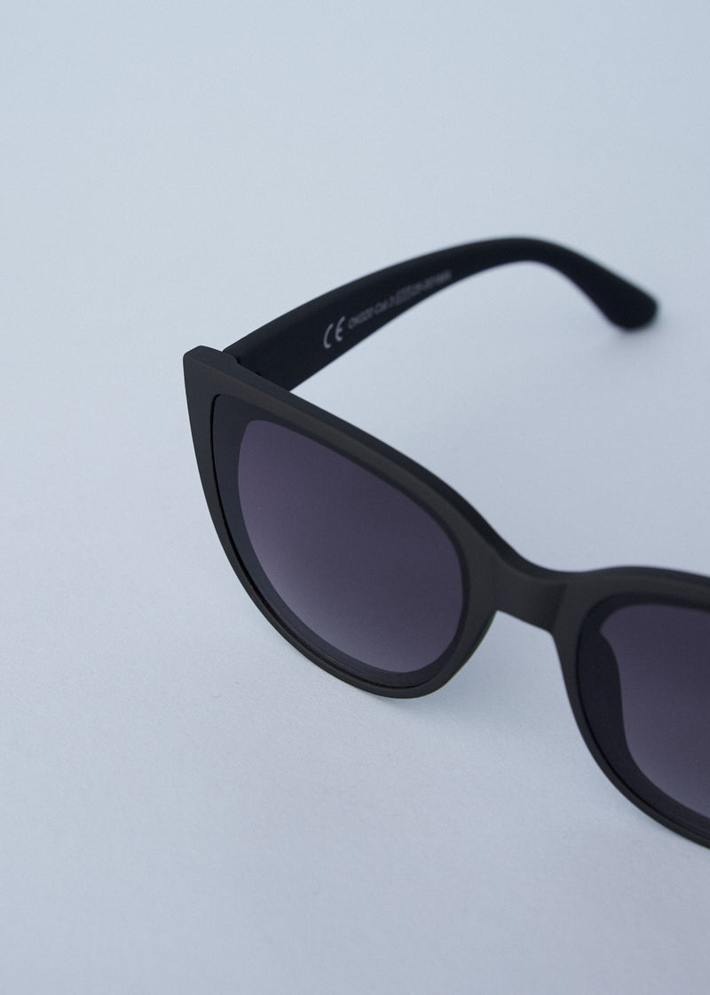 A pair of oversized cat eye sunglasses with black frames and blue lenses