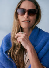 A model wearing a pair of oversized sunglasses with mocha brown coloured frames