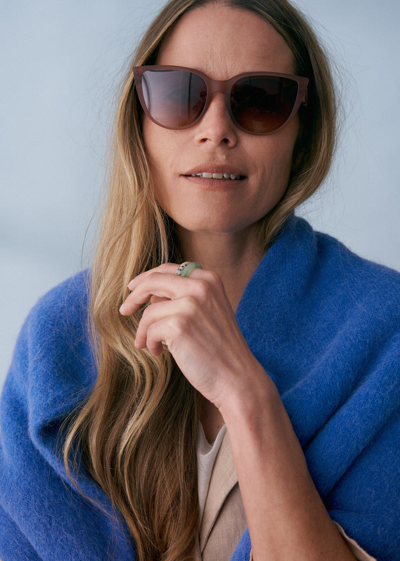 A model wearing a pair of oversized sunglasses with mocha brown coloured frames