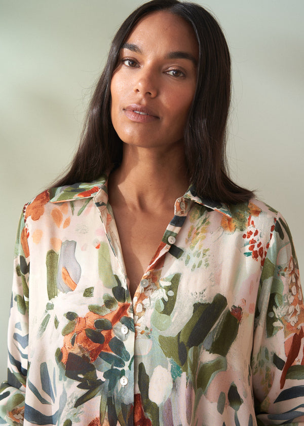Woman wearing a floral maxi dress against a plain background