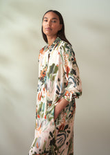 Woman wearing a floral dress against a plain background