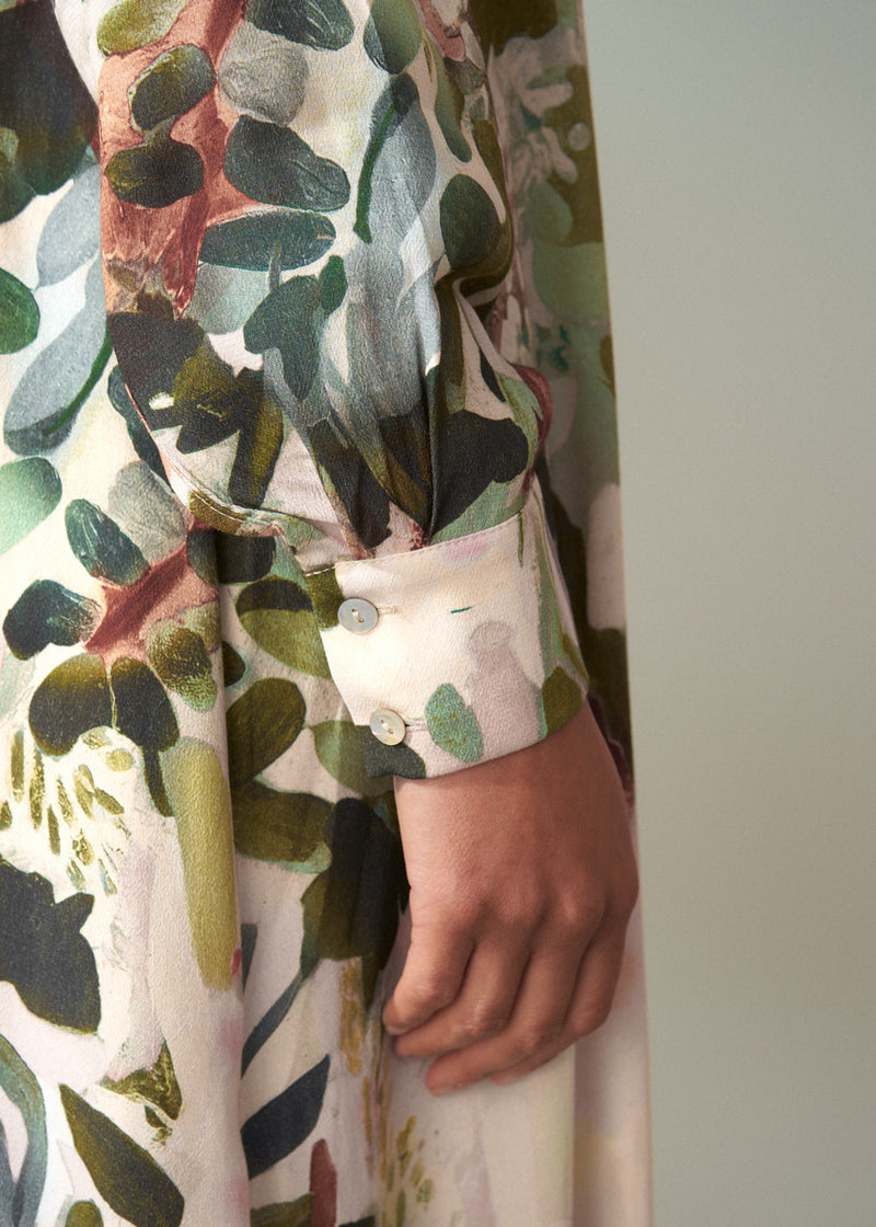 Close-up of a person wearing a floral-patterned dress with a neutral background