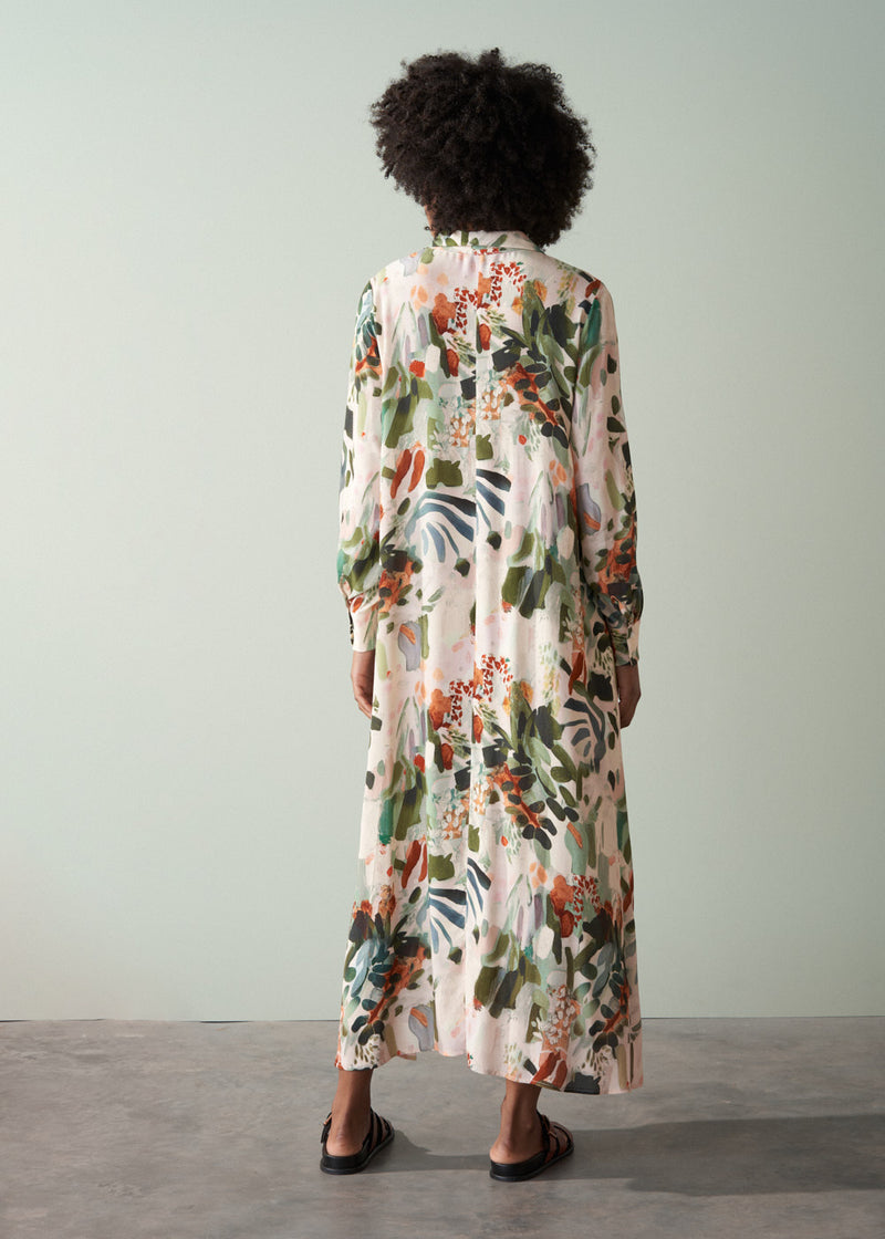 Woman wearing a v-neck floral midi dress, facing a plain background