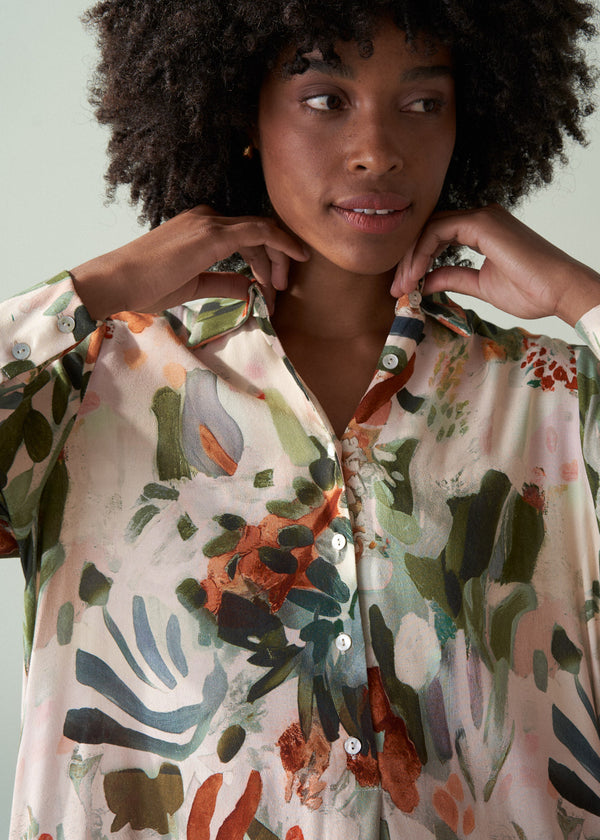 Woman wearing a floral blouse with a neutral background