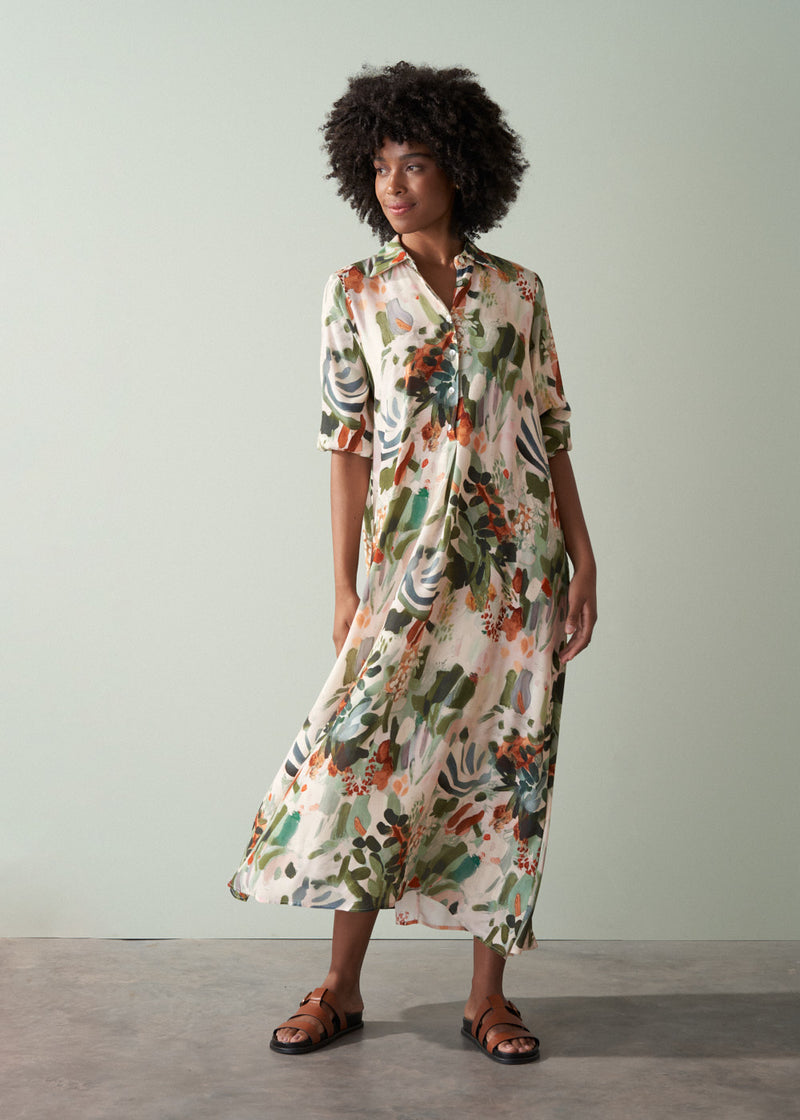 Woman wearing a v-neck floral midi dress against a plain background