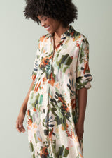 Woman in a floral print v-neck midi dress against a plain background