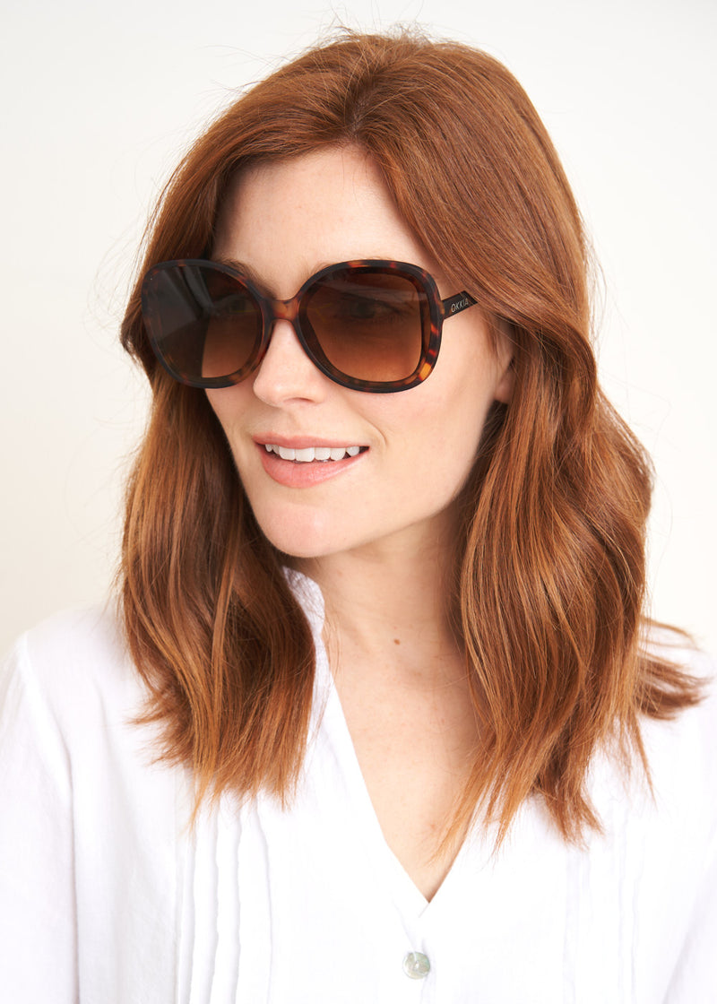 A pair of oversized sunglasses with brown tortoiseshell frames and brown lenses