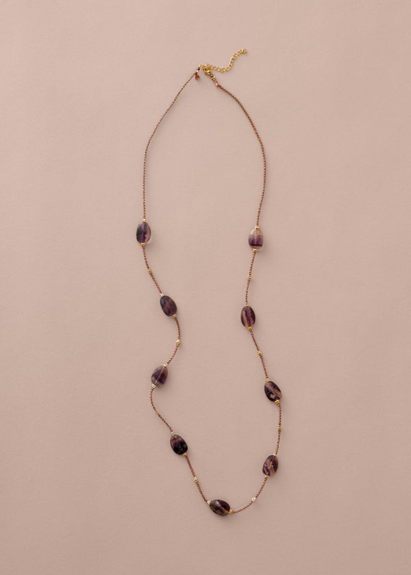 Necklace with purple beads on a beige background
