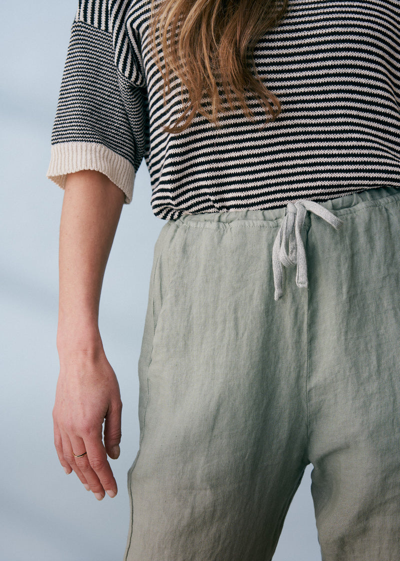 Sage green linen trousers with metallic trim