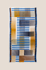 Folded striped towel with blue, white, and beige colors on a light background