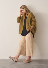 Woman wearing black crinkled cotton a-line top with beige linen trousers