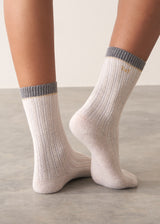 Person wearing heavy knit recycled wool blend socks in neutral and grey with metallic thread detailing and embroidered B&F monogram