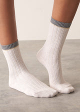 Person wearing heavy knit recycled wool blend socks in neutral and grey with metallic thread detailing and embroidered B&F monogram