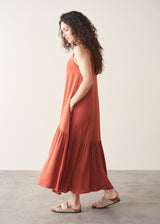 Woman wearing terracotta satin sleeveless midi dress