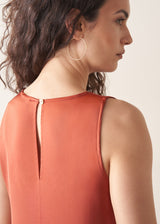 Woman wearing terracotta satin sleeveless midi dress