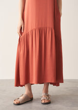 Woman wearing terracotta satin sleeveless midi dress