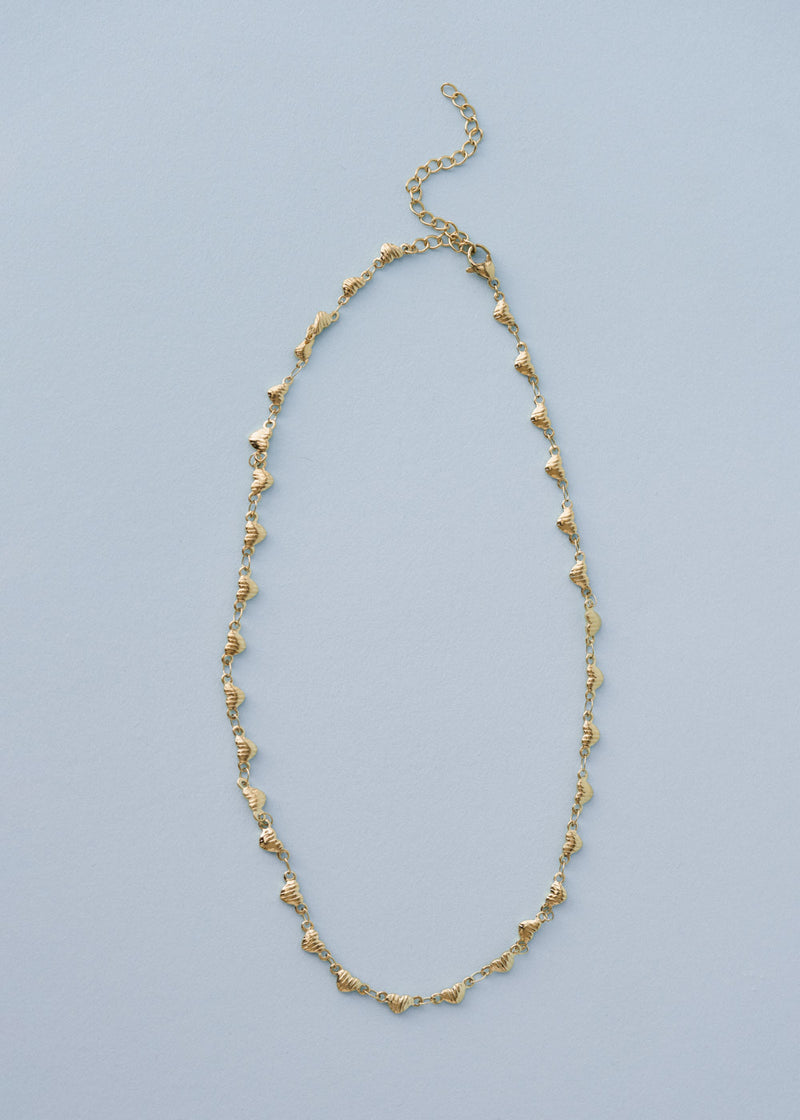 A gold necklace with heart-shaped charms, on blue background