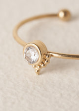 Close up of crystal on dainty everyday gold band ring