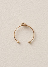 Everyday gold band ring with crystal detail on beige background