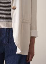 Woman wearing an off-white oversized blazer over with blue denim jeans