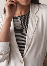 Woman wearing an off-white oversized blazer over with off-white tapered trousers