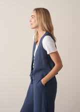 Woman wearing a navy blue linen waistcoat with wide leg linen trousers