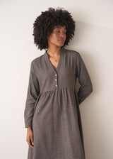 Woman wearing a checked midi dress and chunky boots against a plain background