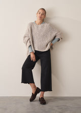 Woman wearing long sleeve pale blue top with black wide leg trousers