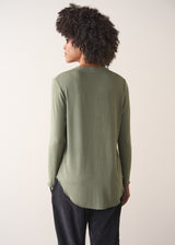 Woman wearing a green long-sleeve t-shirt against a white background