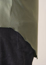 Woman wearing a green long-sleeve t-shirt against a white background