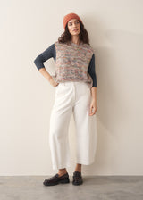 Woman wearing dark grey long sleeve top and white barrel leg jeans