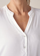 Woman wearing white long sleeve top with black trousers