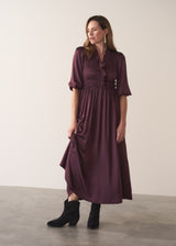 Woman wearing a plum sati midi dress standing against a plain background