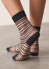 Person wearing black and sheer striped cotton blend ankle socks with ribbed hem
