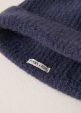 "Busby & Fox" branding on the inside of an ultra soft, alpaca wool blend beanie hat in navy, on a beige background