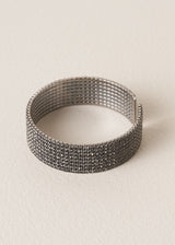 Bracelet cuff with grey diamantes on beige background