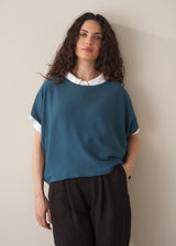 Woman wearing bright blue sleeveless knitted sweater