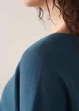 Woman wearing bright blue sleeveless knitted sweater
