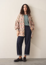 Woman wearing sage short sleeve draped sweater with blue jeans