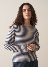 Model wearing blue and white stripe knit sweater and dark grey joggers