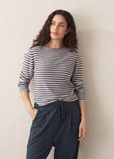 Model wearing blue and white stripe knit sweater and dark grey joggers