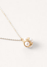 Close up of a cluster pearl necklace on delicate gold chain.