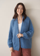 Woman wearing chunky blue cardigan and brown linen trousers