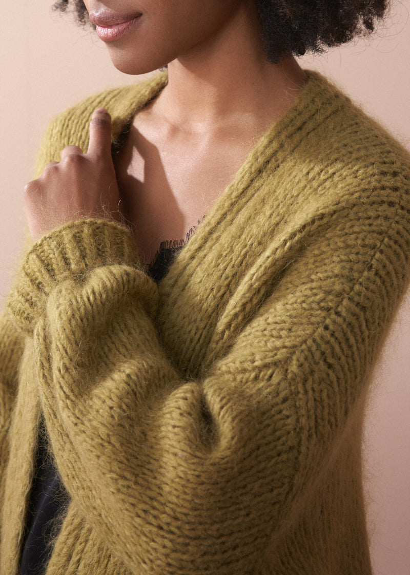 Close up of an olive green chunky knit cardigan