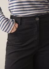 Woman wearing striped sweater and black wide leg cropped trousers