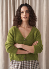 Woman wearing a green wool blend cardigan with check trousers