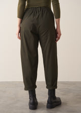 Woman wearing a khaki green top and dark green barrel leg trousers