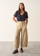 A woman wearing like green linen wide leg cargo trousers and a black t-shirt