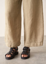 A woman wearing like green linen wide leg cargo trousers and a black t-shirt